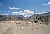 Ladakh - pile of stones on  mountain pass with the characteristc prayer flags